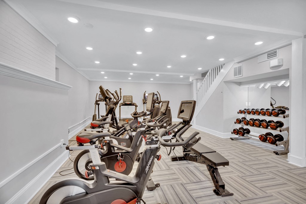 a gym filled with cardio bikes and dumbbells