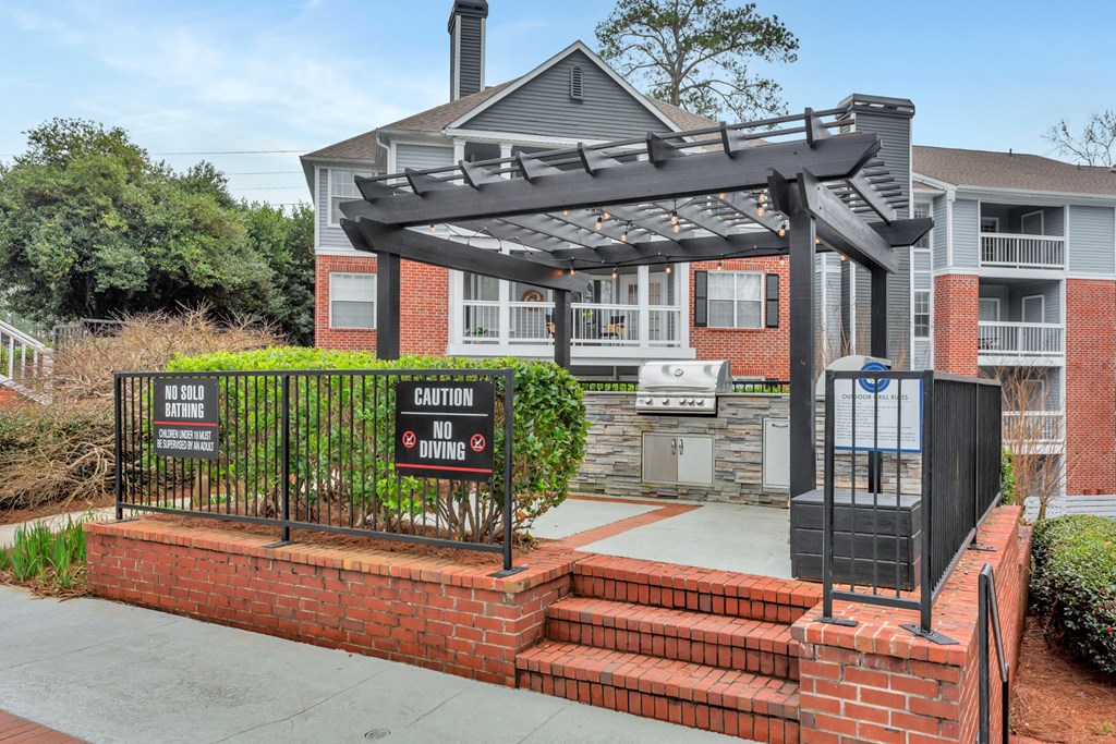 the front of a house with a gate and stairs in front of it