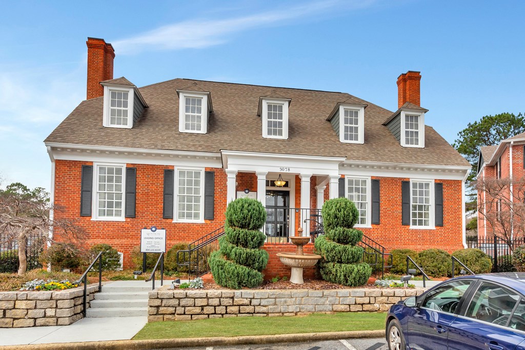 a red brick house with a front porch and a fountain