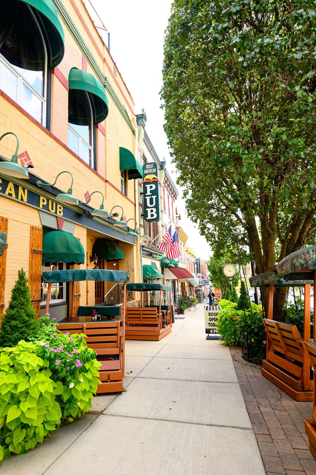 a city street with benches and umbrellas     and trees at Madison West Elm, Pennsylvania