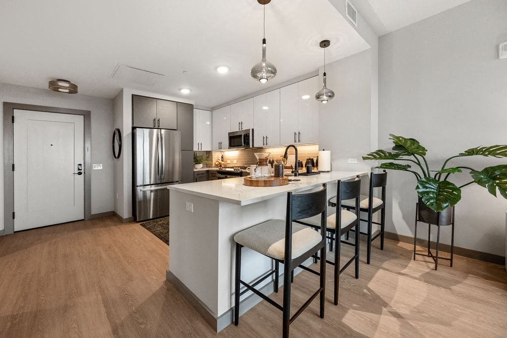 an open kitchen with a large island with bar stools at Madison West Elm, Conshohocken, PA
