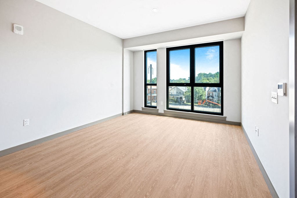 an empty living room with a window and wood floors at Madison West Elm, Conshohocken, PA, 19428