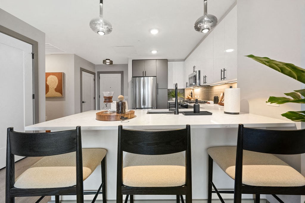 a kitchen with a counter and three black chairs at Madison West Elm, Conshohocken, PA, 19428