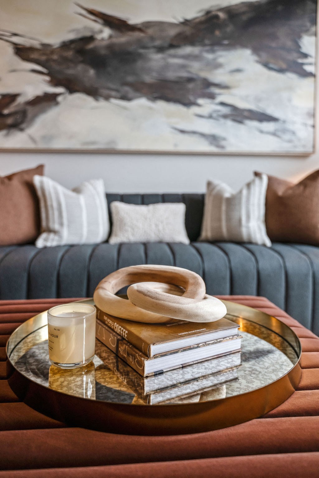 a coffee table with a stack of books and a candle on it at Madison West Elm, Pennsylvania