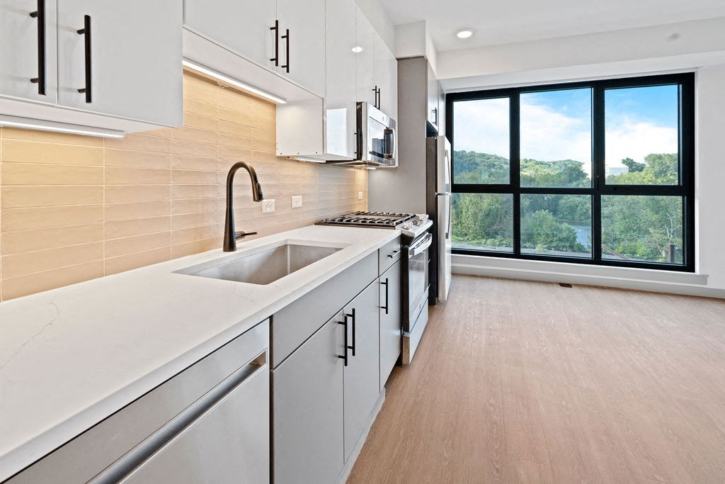 a white kitchen with a sink and a window at Madison West Elm, Conshohocken
