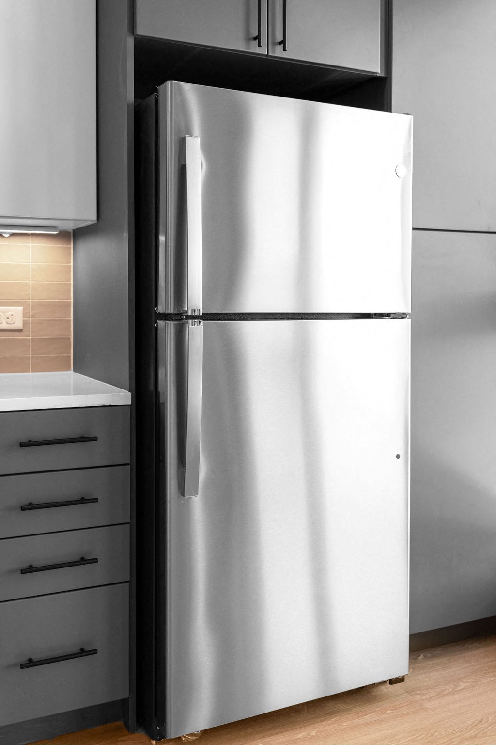 a stainless steel refrigerator in a kitchen with white cabinets at Madison West Elm, Pennsylvania