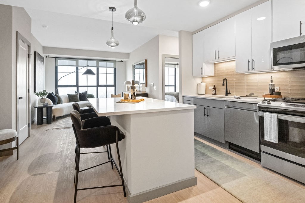 an open kitchen and living room with a large white island at Madison West Elm, Conshohocken, PA, 19428