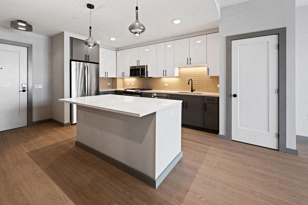 a white kitchen with a large island in the middle at Madison West Elm, Conshohocken