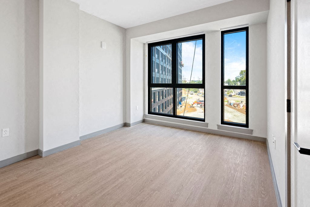 an empty living room with large windows and wood floors at Madison West Elm, Conshohocken, 19428