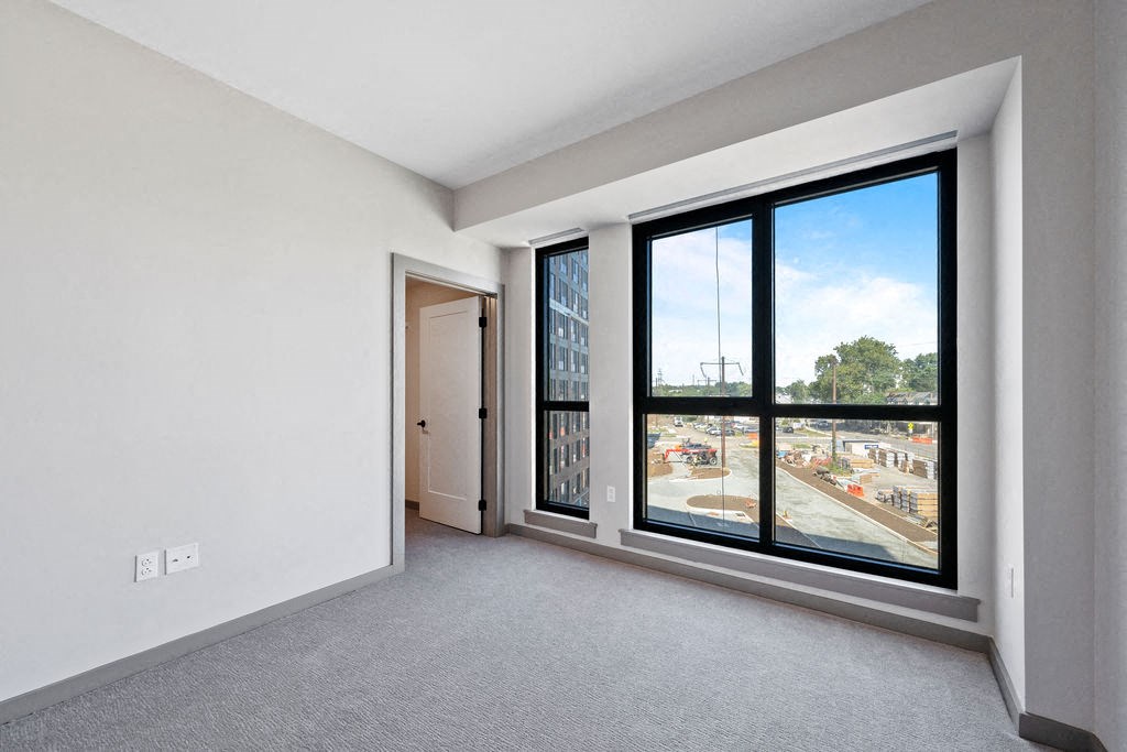 a living room with a large window and a door to the street at Madison West Elm, Conshohocken
