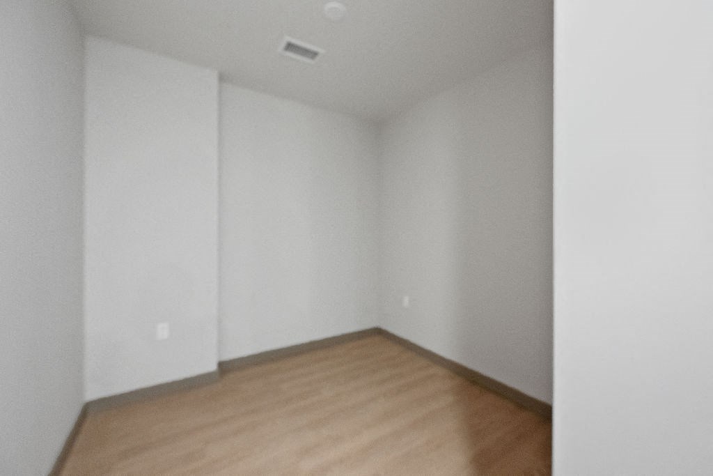 an empty room with white walls and wooden floors at Madison West Elm, Conshohocken