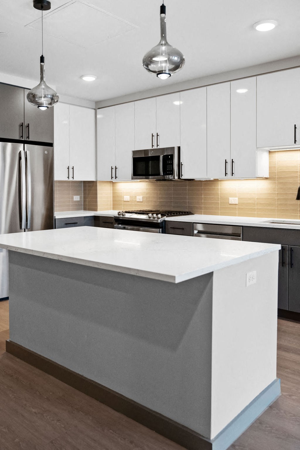 a white kitchen with a large island and stainless steel appliances at Madison West Elm, Pennsylvania, 19428