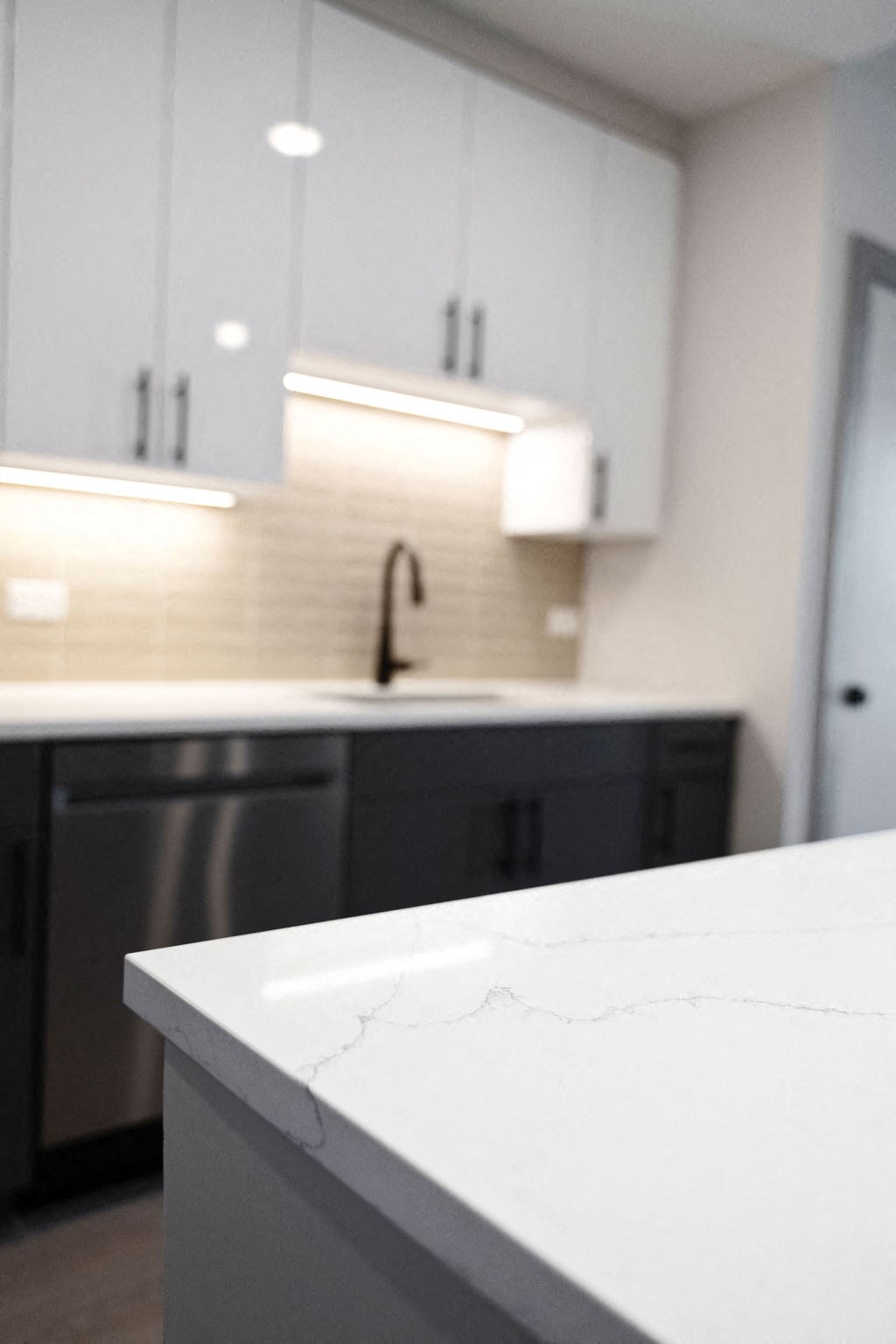 a white kitchen with black cabinets and white counter tops at Madison West Elm, Pennsylvania, 19428