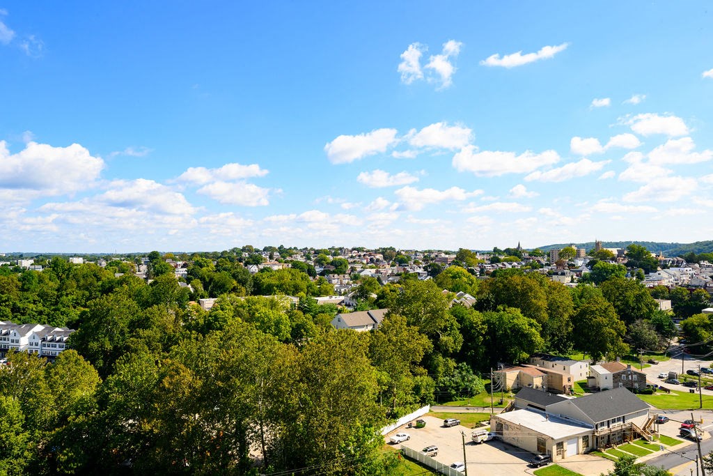 an aerial view of a city with trees and rooftops at Madison West Elm, Conshohocken, 19428