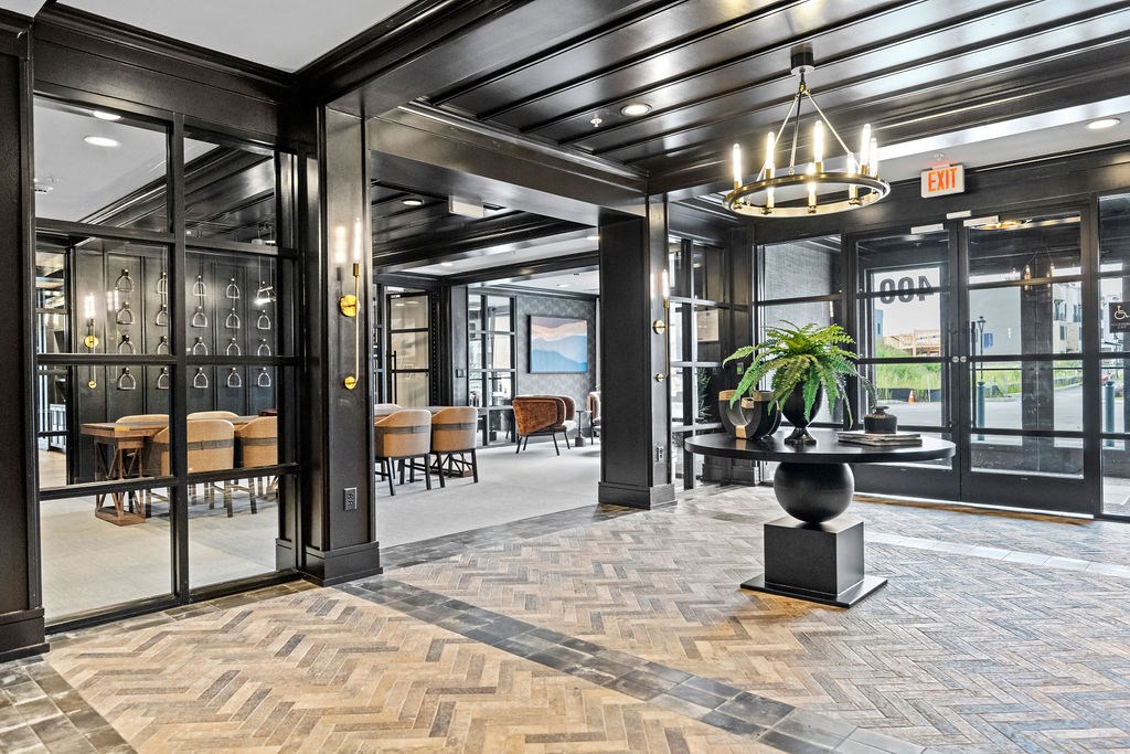 a lobby with glass doors and a table with a plant at The Harrison, Newtown Square