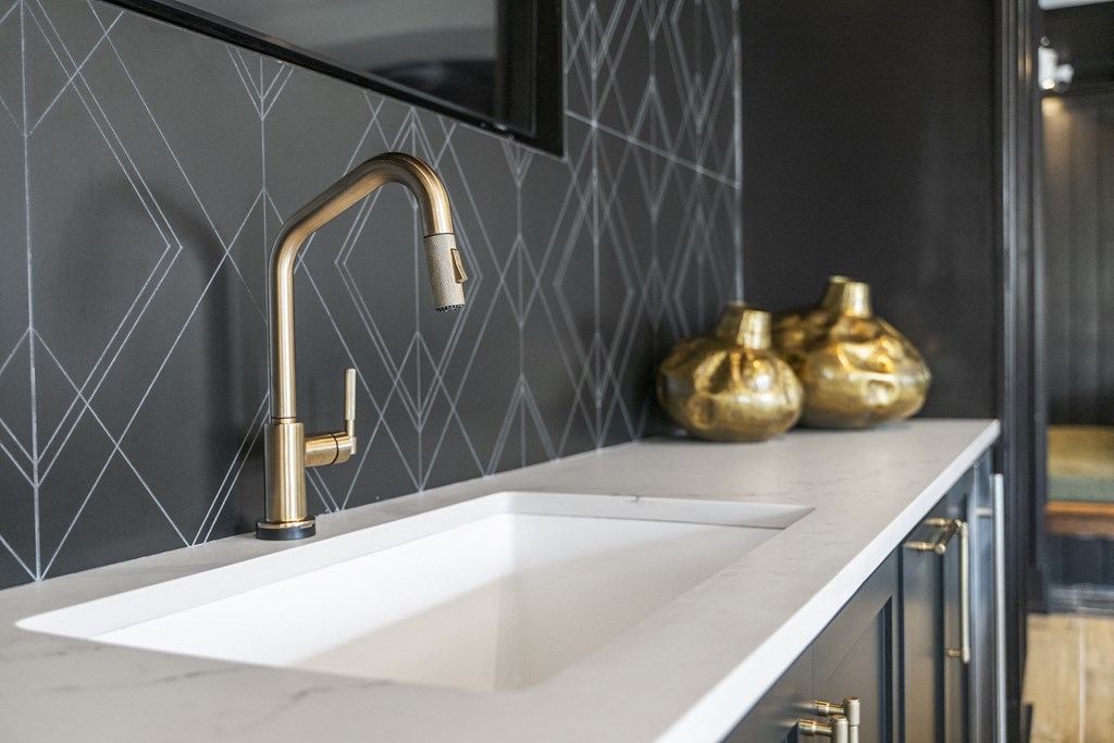 a white sink with a gold faucet in a black and white kitchen at The Harrison, Newtown Square, PA, 19073