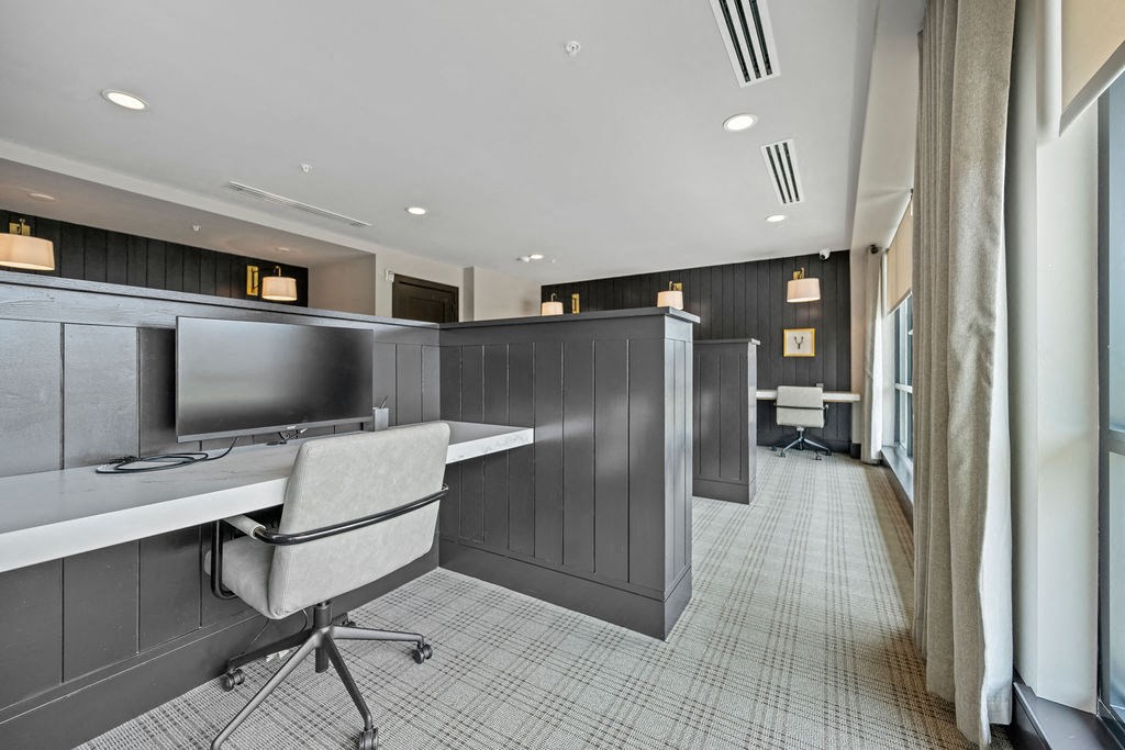 a lobby with desks and chairs and a tv at The Harrison, Newtown Square, PA