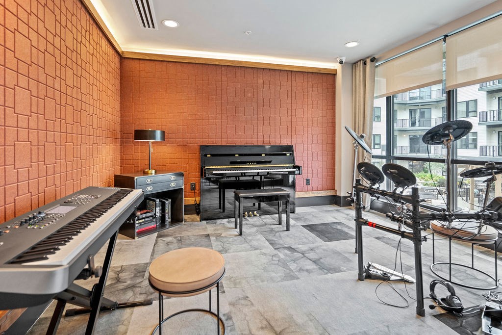 the music room has two keyboards and two pianos and a large window at The Harrison, Newtown Square, PA