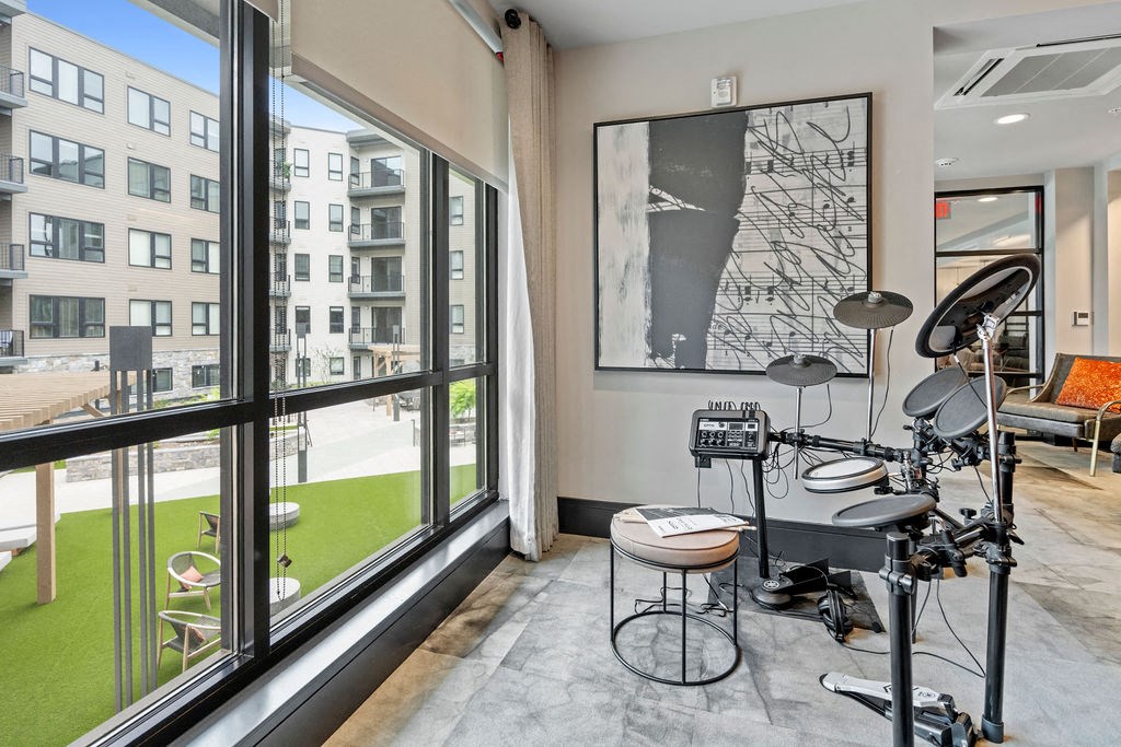 a music room with a drum set and a large window at The Harrison, Newtown Square, Pennsylvania