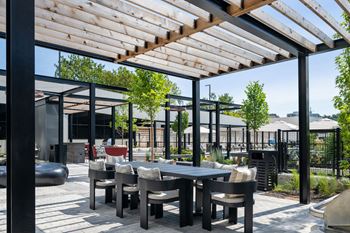a patio with a table and chairs under a pergola at Madison West Elm, Conshohocken, PA