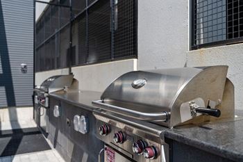 A row of stainless steel grills with a red and white sign on the front at Madison West Elm, Conshohocken, 19428