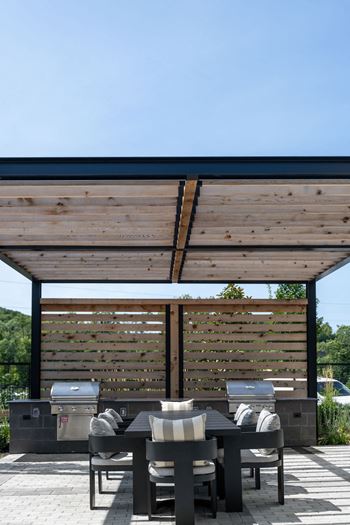 A wooden pergola with a table and chairs underneath it at Madison West Elm, Pennsylvania, 19428