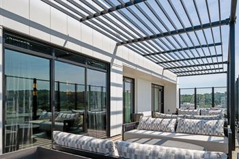A modern patio with a glass wall and a metal pergola at Madison West Elm, Pennsylvania