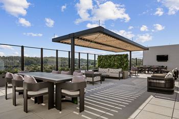 A patio with a table and chairs under a roof at Madison West Elm, Conshohocken