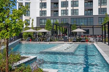A large swimming pool in front of a multi-story building at Madison West Elm, Pennsylvania