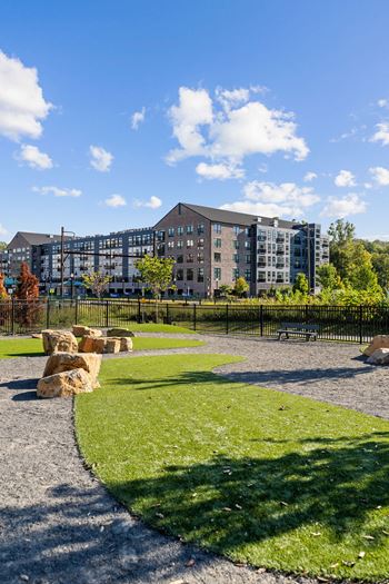A park with a grassy area and a building in the background at Madison West Elm, Pennsylvania, 19428
