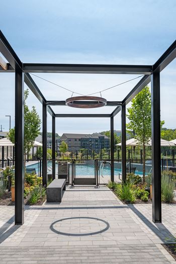 A pool area with a walkway and a bench at Madison West Elm, Conshohocken, PA 19428