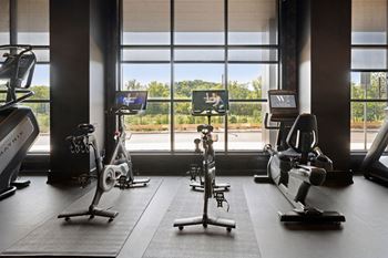 A gym with exercise equipment and a view of the outdoors through the windows at Madison West Elm, Conshohocken, PA 19428