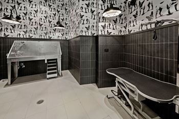 A bathroom with a tiled wall and a bench at Madison West Elm, Conshohocken, 19428