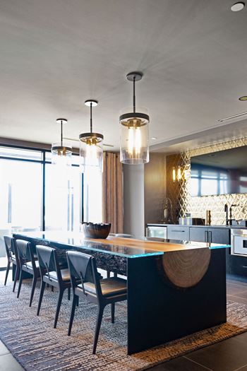 A modern kitchen with a long table and chairs at Madison West Elm, Conshohocken, PA