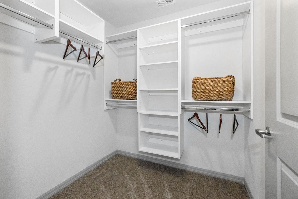 a walk in closet with white shelves and a white closet door at Inspira, Naples, 34113