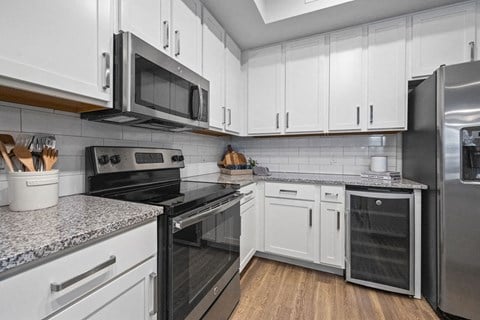 a kitchen with white cabinets and stainless steel appliances