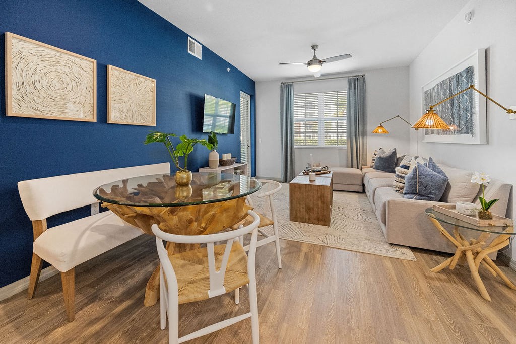 a living room with a blue accent wall and a table at Inspira, Naples, FL, 34113