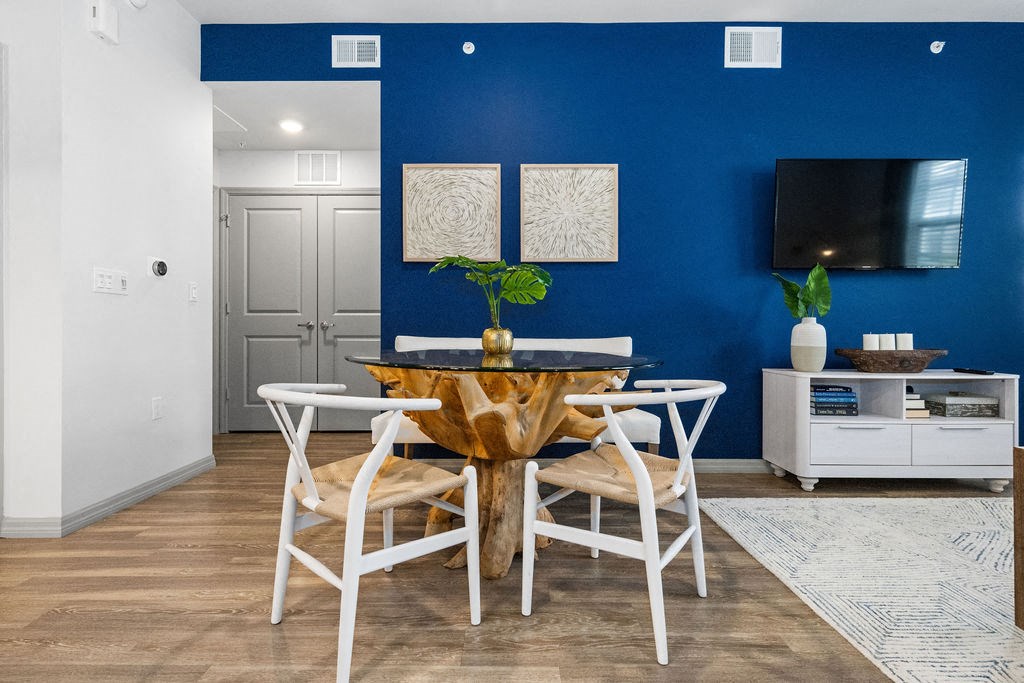a dining room with a table and chairs and a tv at Inspira, Naples, Florida