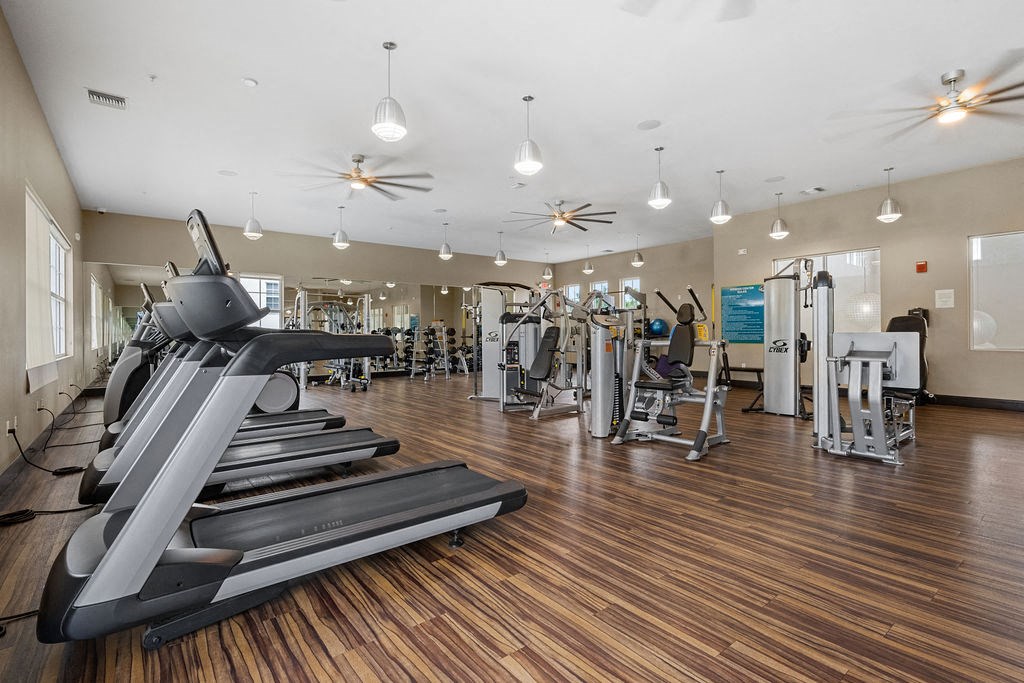 a gym with cardio equipment and weights on a wooden floor at Inspira, Florida, 34113