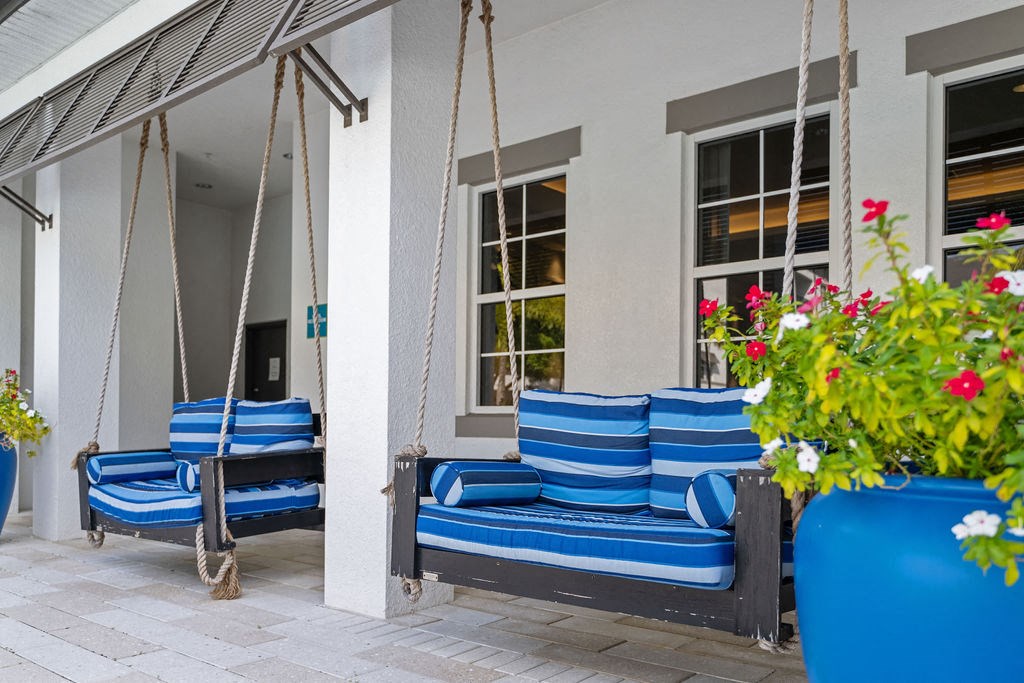 two love seat size swings with blue cushions outside the clubhouse at Inspira, Naples, FL