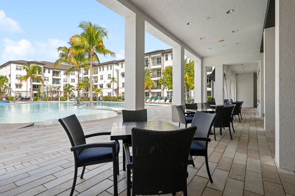 a large patio with tables and chairs next to a pool at Inspira, Florida