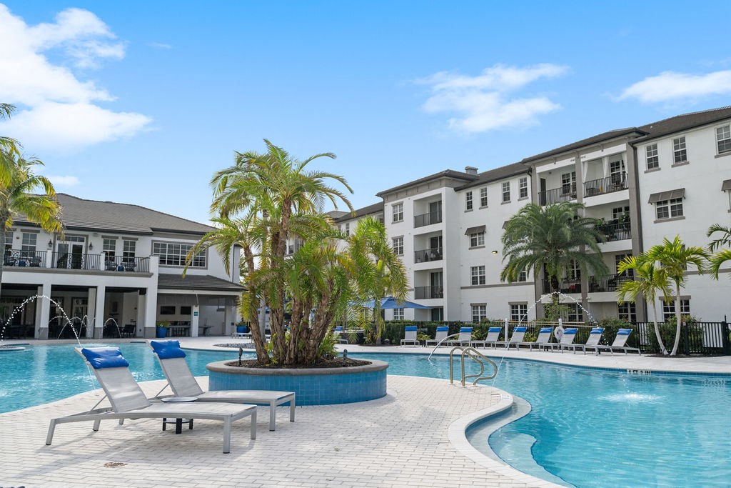 The pool with many lounge chairs and islands with palm trees at Inspira, Naples, FL