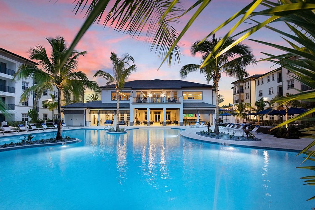 a large swimming pool in front of a resort with palm trees at Inspira, Florida