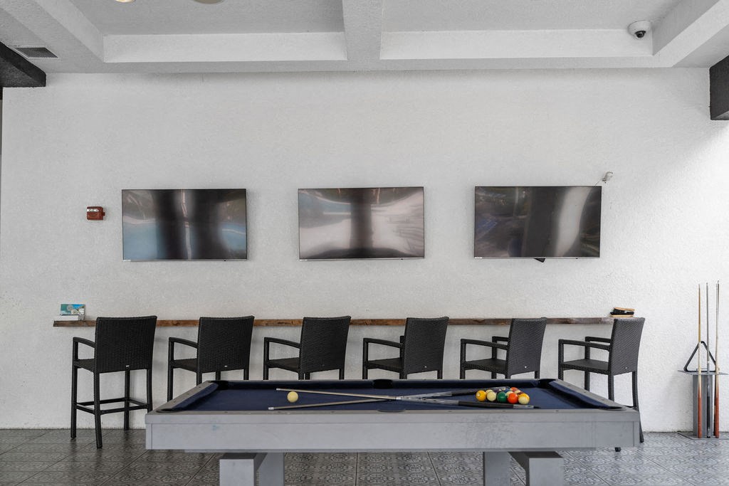 a pool table and chairs in a room with pictures on the wall at Inspira, Florida, 34113