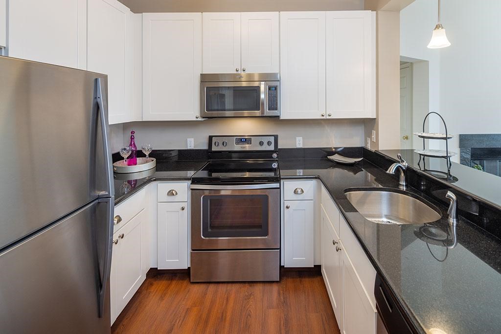 A modern kitchen with a stainless steel refrigerator and a stainless steel oven.