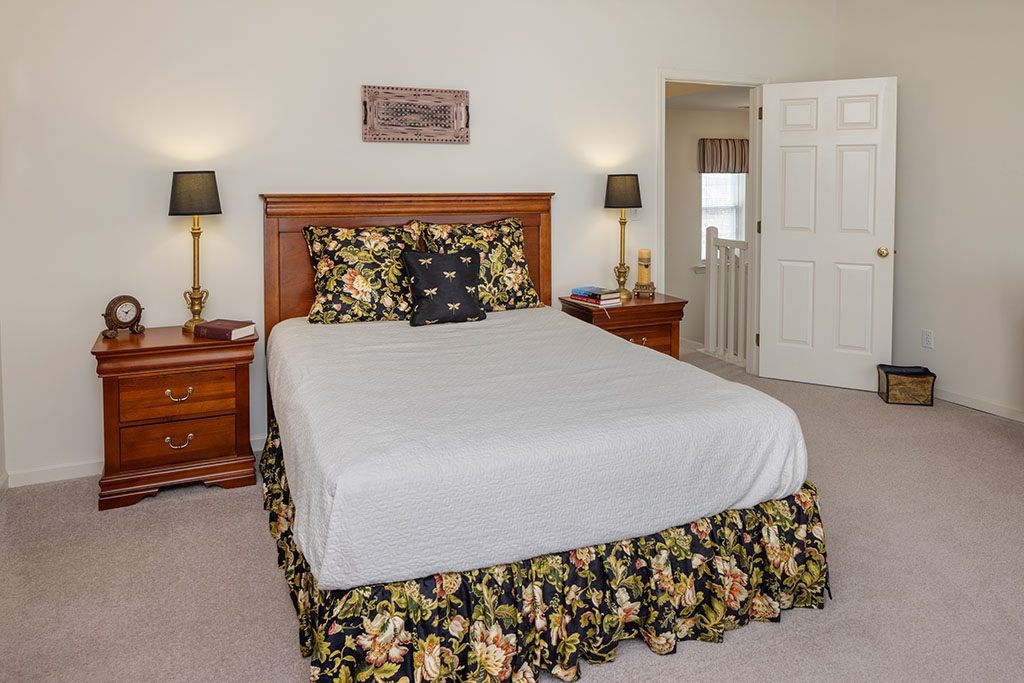 A bedroom with a large bed and a wooden headboard.