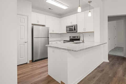 A kitchen with white cabinets and a granite countertop.