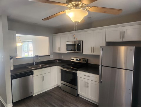 A kitchen with white cabinets and stainless steel appliances.