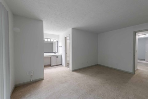 A spacious room with a window and a door leading to another room.