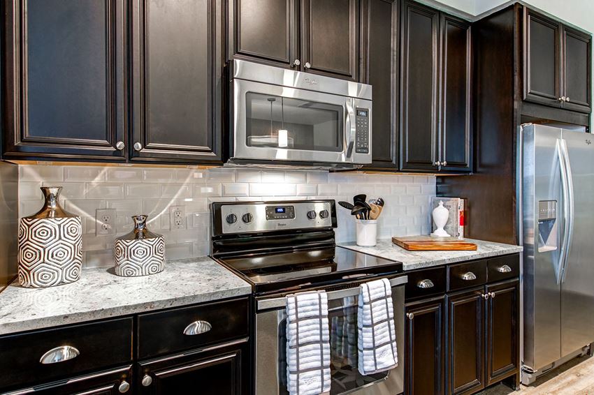Kitchen Kitchen with espresso cabinetry, burshed nickel hardware, stainless steel range and built in microwave at McKinney Village, Texas, 75069 - Photo Gallery